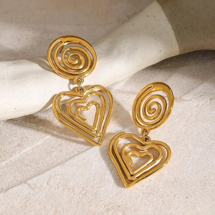 Elegant gold-plated stainless steel heart earrings with a unique swirling design, perfect for romantic outfits.