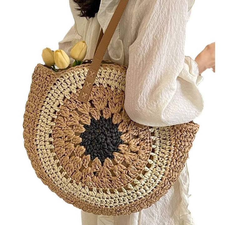 Colorful round woven straw bag with floral pattern, ideal for casual beach outings.
