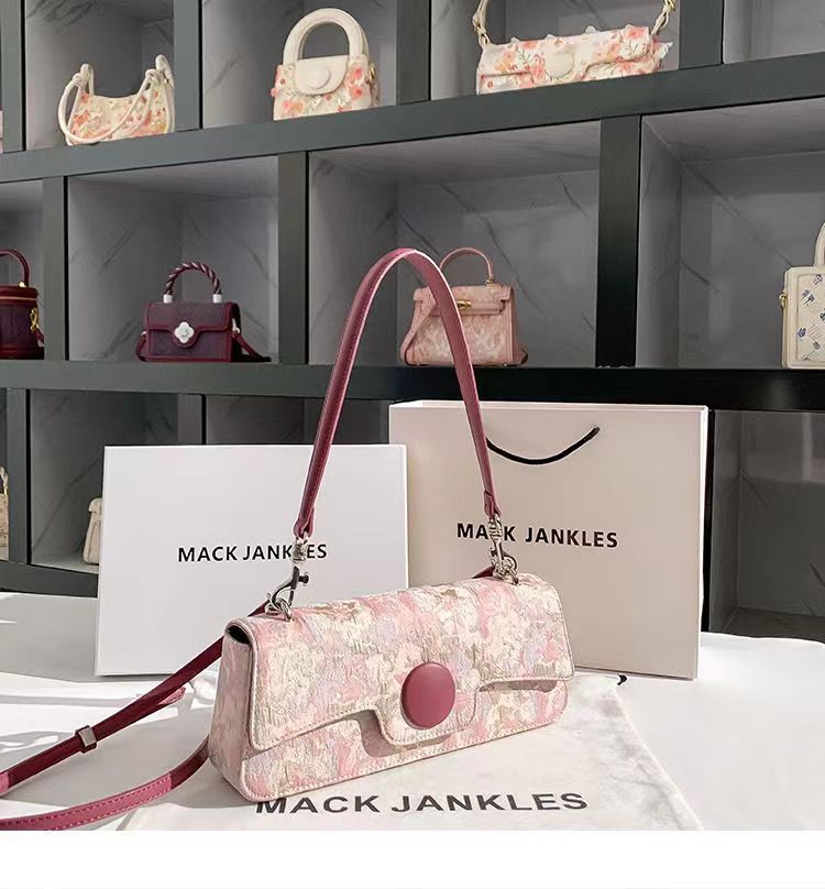 Floral handbag with pink strap on a white surface with 'Mack Jankles' branding.