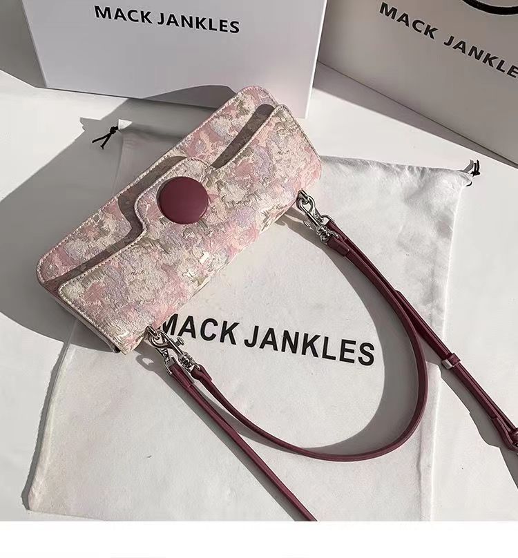 Pink floral patterned wallet with a strap on a white surface with 'MACK JANKLES' branding.
