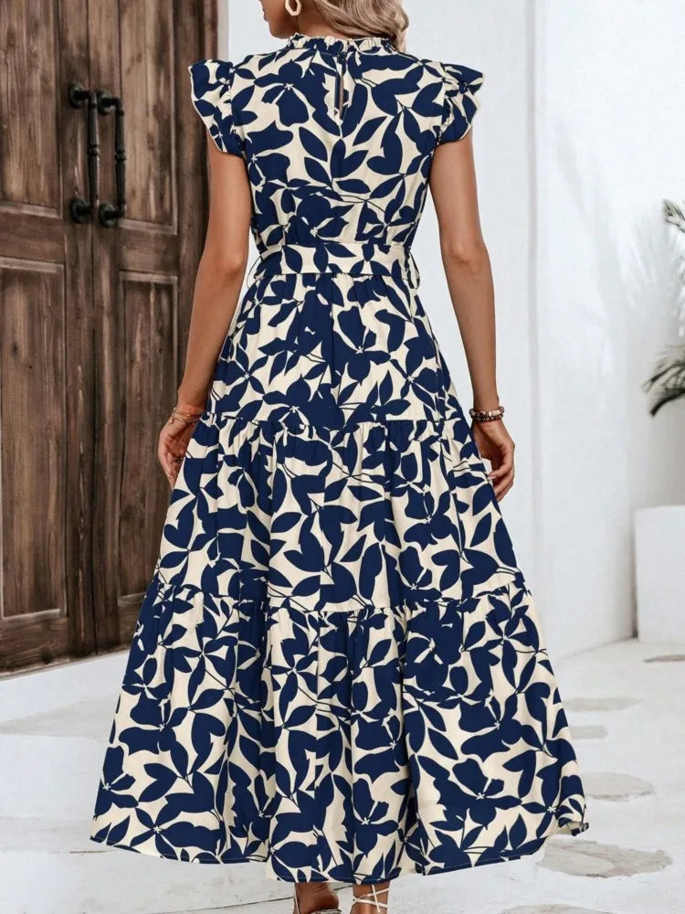 Woman wearing a blue and white floral dress indoors.
