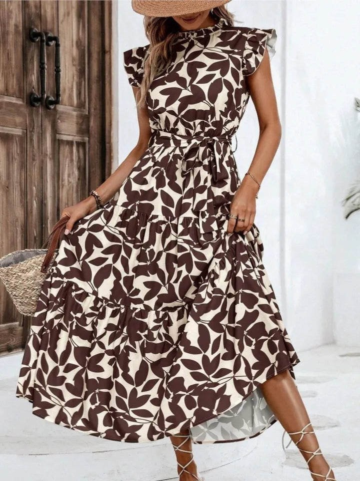 Woman wearing a brown and white floral midi dress in an indoor setting.