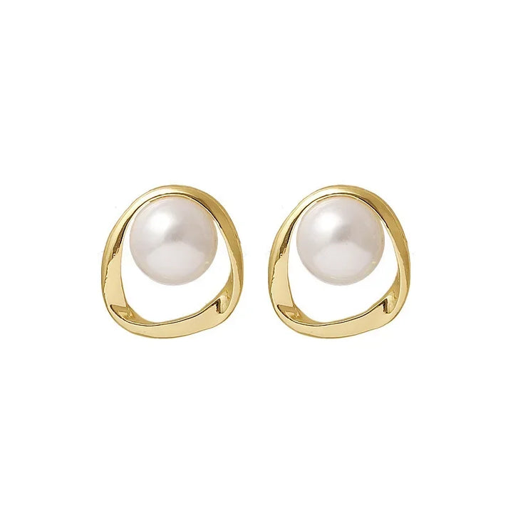 Pair of gold pearl drop earrings with pearl centers on a white background