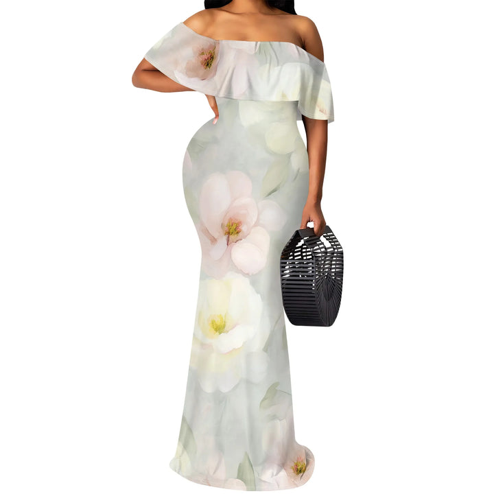 Woman wearing a light green floral off-shoulder dress holding a black handbag on a white background