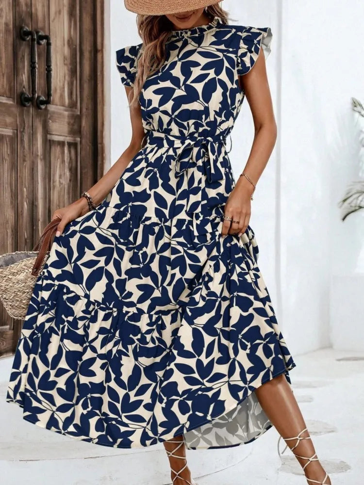 Woman wearing a blue and white floral dress indoors.