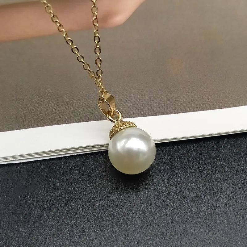 Pearl necklace with gold chain on a dark surface
