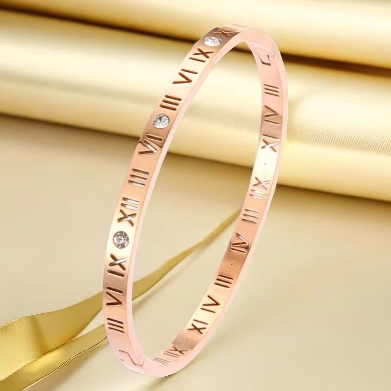 Elegant women's rose gold bracelet featuring Roman numerals and crystals against a luxurious gold background.