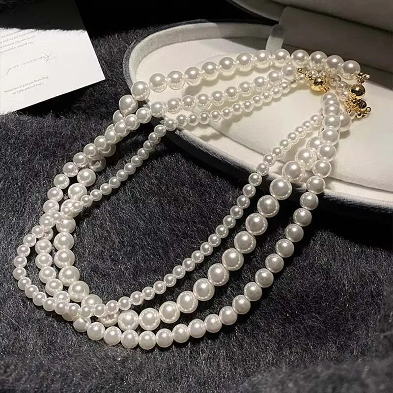 Elegant white pearl necklace with multiple strands in a jewelry box, featuring a magnetic clasp.