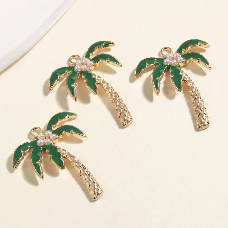 Gold coconut palm tree charms with green leaves and pearl accents, ideal for jewelry making supplies.