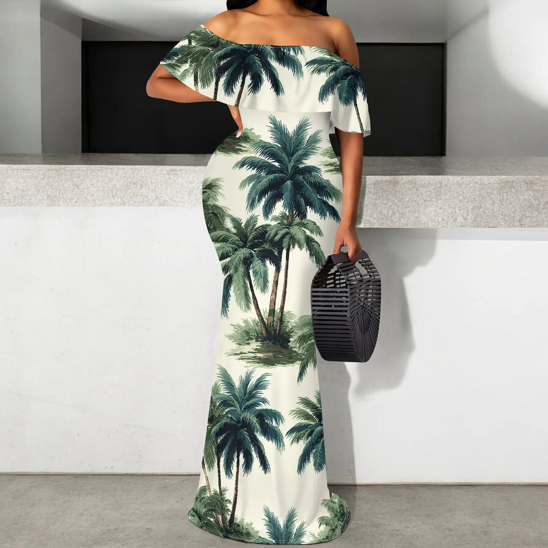 A woman wearing a palm tree summer off-shoulder dress holding a black handbag.