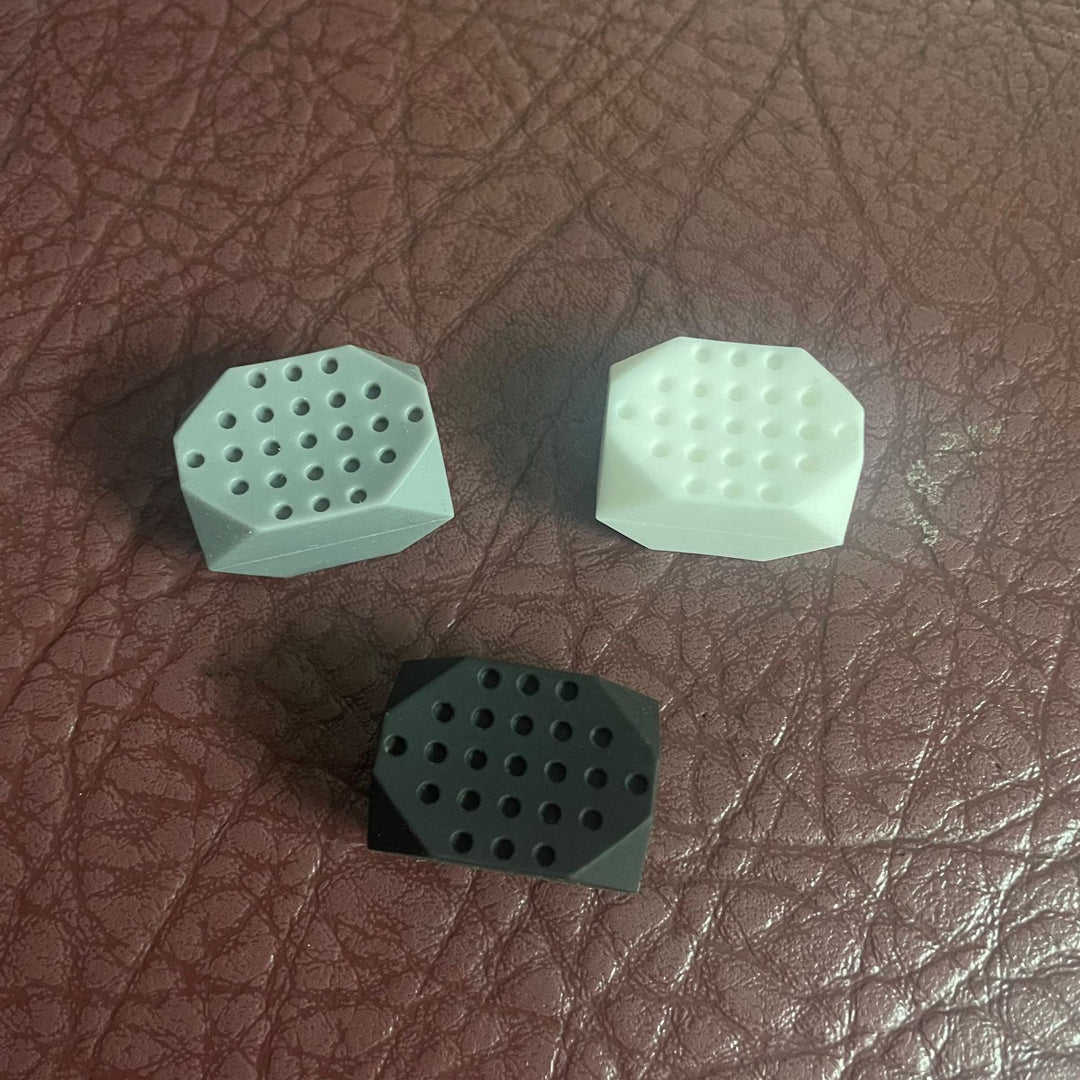 Three Mini Jawline Exerciser on a brown leather surface