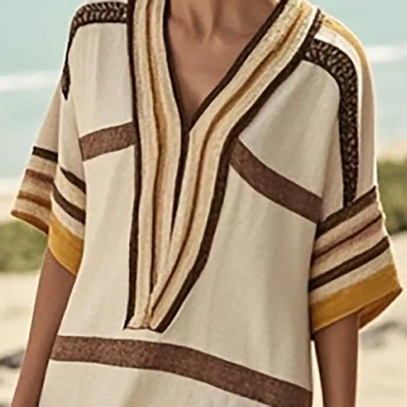 Close-up of a woman wearing a vintage stripe print midi dress with earthy colors and a stylish V-neck design.
