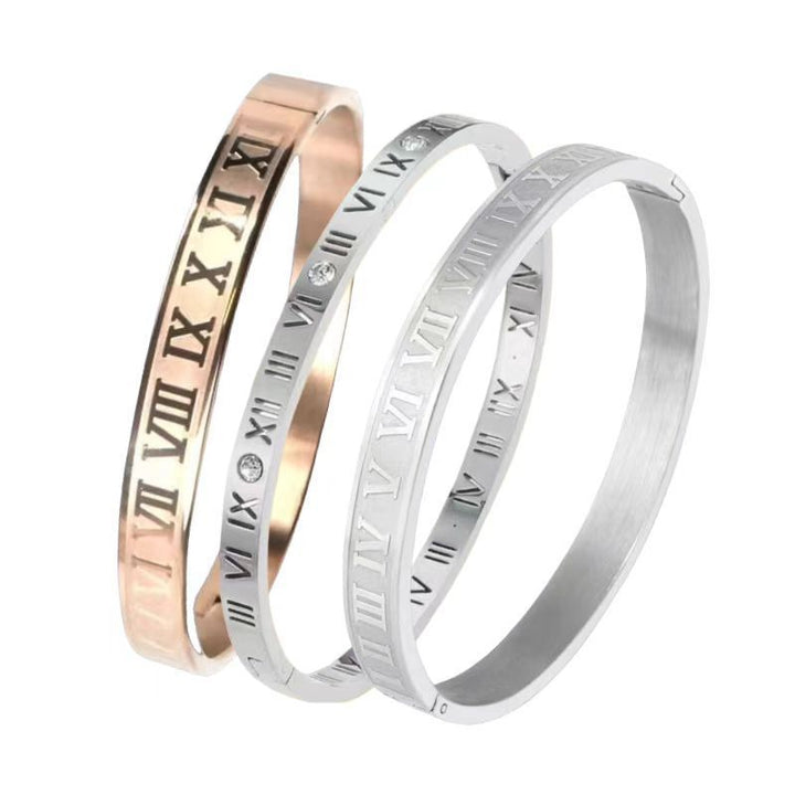 Set of three elegant bracelets in rose gold, silver, and grey with Roman numeral engravings.
